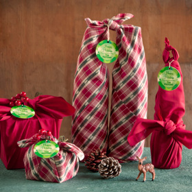 1. Umístěte dárek do středu šátku položeného nakoso. Svažte dva protilehlé cípy k sobě a „vycentrujte“ uzel nad dárkem. Totéž udělejte se zbývajícími dvěma cípy. Oba kroky ještě jednou zopakujte a máte hotovo. Dárek můžete ještě vylepšit tím, když do uzlu zapíchnete dekoraci.