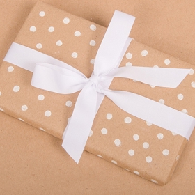 3. Zabalte dárek do obyčejného hnědého papíru. Vezměte si tužku s gumou na konci, tu namočte do bílé barvy a obtiskněte na papír puntíky. Dárek můžete ještě převázat mašlí sladěnou s barvou puntíků.