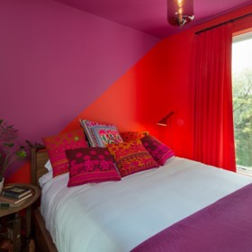 3. Tuto netradiční ložnici pro hosty navrhla Chelsie Lee. Kombinace červené a fialové jistě vyvolává tvůrčí sny.