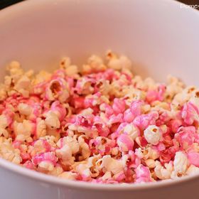 Jakmile teplota dosáhne 110 °C, hrnec odstavíme, vmícháme vanilku a potravinářské barvivo a směs rychle přelijeme přes popcorn. Měl by být úplně obalený v polevě.