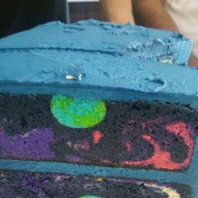 Korpusy nakonec promazal dortovým krémem a dort potáhl fondánem. Vše samozřejmě v temně modré barvě, jednom z odstínů vesmíru.