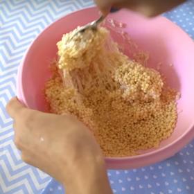 Smícháme rýžové vločky s maršmelounovým krémem. S hmotou by mělo jít pracovat jako s modelínou, dle potřeby tedy přidáme krém nebo vločky.