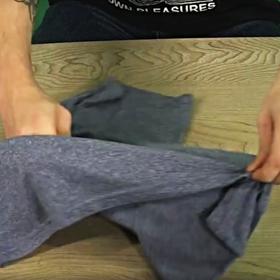 3. Teď už jen zbývá udělat magický pohyb. Překřížené ruce vraťte do přirozené polohy, trochu s tričkem zatřeste, aby se vyrovnalo, a přeložte jej.