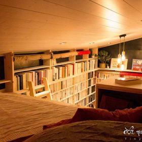 Jacques přespává v patře s výhledem na regály plné knih.