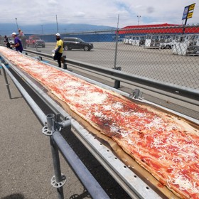 Rekordní slaný koláč připravovali pizzaři na okruhu Auto Club Speedway v kalifornském městě Fontana. Padlo na něj 3,6 tun těsta.