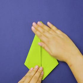 2. Uchopíme růžky ubrousku a přehneme je směrem dovnitř na střed.