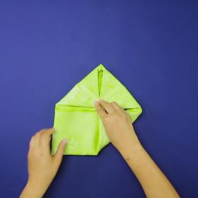 3. Ubrousek obrátíme a znovu překládáme rohy na střed.