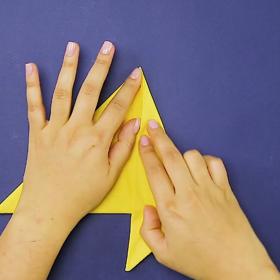 1. Ubrousek přeložíme napůl od rohu k rohu a postranní růžky přehneme směrem na střed dle obrázku.