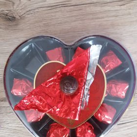 Čokoládová růže z tmavé čokolády s náplní z višní v alkoholu v retro obalu. Cena srdce 106 g je 70 Kč.