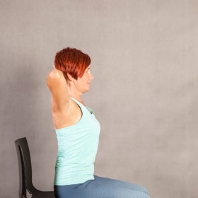 Sedněte si na židli. Zvolte takovou, abyste měli chodidla na zemi a v kolenou 90°. Nohy mějte na šířku kyčlí, špičky směřují dopředu. Seďte rovně, dejte ruce v týl, tlačte ramena dolů a lopatky k sobě.