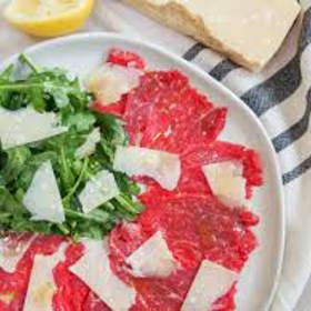 Carpaccio s rukolou

Suroviny:

parmazán
100 g rukola
400 g tenké hovězí plátky

marináda:
2 ks citron
100 ml olivový olej
mletý pepř
sůl

Postup:

Marináda: Vymačkáme citrony a profiltrujeme. Přidáme olivový olej, sůl a mletý pepř. Vidličkou promícháme.

Připravené maso na carpaccio necháme připravit nejlépe od řezníka. Libové maso musí být zbavené nervů a nakrájeno na velmi slabounké plátečky.

Slaboučké plátky necháme alespoň na 10 minut v citronové marinádě v lednici. Pokud nechceme, aby maso ztratilo růžovou barvu, nedáme ho do lednice marinovat, ale rozdělíme maso na 4 talíře, pokropíme připravenou citronádou a každý talíř posypeme 25 g čisté osušené rukoly a 25 g hoblinkami parmazánu.

Hovězí carpaccio s rukolou a parmazánem podáváme s čerstvým pečivem, solí, pepřem a olivovým olejem, abychom si carpaccio mohli dochutit dle naší chuti.