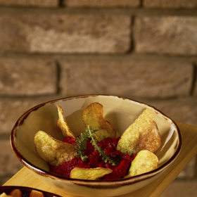 Pesto z červené řepy s bramborovými chipsy:
Předpříprava řepy:
500 g řepy
5 g tymiánu
30 g olivového oleje
mořská sůl.
Neoloupanou řepu zabalte s tymiánem, mořskou solí a olivovým olejem do alobalu. Pečte při 160 °C, dokud řepa není měkká. Po vychlazení oloupejte.
Pesto z pečené řepy
360 g řepy upečené
60 g olivového oleje
10 g česneku oloupaný
80 g pinie
30 g parmazánu, jemně strouhaný
sůl.
Do mixéru dejte nejprve řepu, česnek a olej. Rozmixujte dohladka a pak přidejte pinie, krátce rozmixujte a nakonec přidejte parmazán. Krátce rozmixujte a dochuťte solí.
Bramborové chipsy
50 g brambor
olej na smažení.
Neloupané brambory nakrájejte na tenké plátky, propláchněte, osušte a usmažte při 160 °C dozlatova.