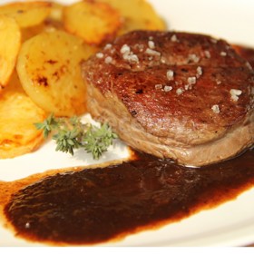 Steak s jahodovou omáčkou

Suroviny:

800 g hovězího nízkého roštěnce
100 ml sweet and chilli omáčky
mořská sůl
olivový olej
20 g másla

800 g jahod
2 špetky čerstvě mletého kardamomu
50 ml růžového vína na zředění omáčky
sůl

100 g másla
2 čekanky
50 ml javorového sirupu
100 g vlašských ořechů
špetka soli
olivový olej

Postup:

Hovězí roštěnec nakrájíme na porce po 200 g a marinujeme je ve sweet and chilli omáčce, ideálně přes noc. Maso pečeme na pánvi do růžova z obou stran, po upečení osolíme a poklademe plátky másla.

Polovinu dávky jahod rozmixujeme s vínem, ochutíme kardamomem a krátce společně provaříme, aby se uvolnila chuť koření. Do hotové omáčky vložíme těsně před podáváním druhou část nakrájených jahod.

Čekanku nakrájíme podélně na ¼ a na přepuštěném másle ji krátce prohřejeme s javorovým sirupem, zasypeme sekanými vlašskými ořechy. Steak podáváme s jahodovou omáčkou a čekankou, na talíři vše jemně zakápneme olivovým olejem.