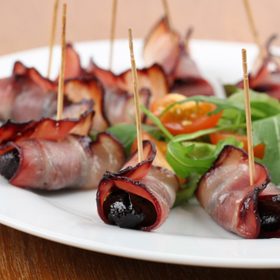 Sušené švestky ve slanině:

Suroviny:

20 sušených švestek, 20 oříšků (nejlépe chutnají mandle nebo para ořechy), 10 plátků slaniny, 1 dcl portského vína, párátka.

Postup:

Nejdříve dejte švestky do misky, zalejte je portským vínem a nechte je 15 minut odležet. Pak do každé švestky vmáčkněte oříšek a obalte ji anglickou slaninou. Do každé švestky zapíchněte párátko a dejte je zprudka nasucho opékat na pánev. Podávejte vychlazené.