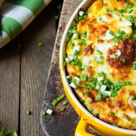 Zapečené nové brambory:

Suroviny:

1 - 2 ks červená cibule,
2 lžíce
čerstvý rozmarýn,
150 ml mléko,
100 g sýr gouda,
 sůl,
mletý černý pepř,
2 lžíce máslo.

Postup:

Nové stejně velké brambory řádně omyjeme a vložíme do vroucí osolené vody. Brambory vaříme asi 10 - 12 minut do poloměkka, potom je slijeme a necháme chladnout.

Mezitím oloupaný česnek a cibuli nakrájíme na drobné proužky a čerstvý rozmarýn jemně nasekáme. V pánvi rozpustíme máslo s olejem, na kterém necháme cibuli, česnek a rozmarýn zpěnit. V míse rozšleháme vejce se smetanou a mlékem a zálivku podle chuti osolíme a opepříme. Tvrdý sýr jemně nastrouháme.

Zchladlé brambory i se slupkou nakrájíme na plátky silné asi 4 mm a opatrně je promícháme s orestovanou cibulovou směsí. Vše rozložíme v tenčí vrstvě do pekáče, zalijeme vaječnou zálivkou a posypeme sýrem. Nové brambory pečeme v předehřáté troubě při 180 °C přibližně 30 minut dozlatova.

Zapečené nové brambory můžeme podávat jako sytou přílohu k lehčím pokrmům, jako jsou ryby, ale i jako samostatný chod se zeleninovým salátem.
