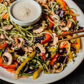 Asijské raw nudle

Suroviny:

Ingredience na nudle (2 porce):

červené zelí
hrst naklíčeného mungo fazolek
1 cuketa
4 mrkve
2 papriky
sezamová semínka
2 žampiony marinované v tamari, oleji, troše vody
čerstvá chilli paprička
čerstvý koriandr

Ingredience na zálivku:

1 stroužek česneku
1 cm zázvoru
šťáva z 1/2 limety
100 g kešu
olivový olej
sůl
pepř
1 lžíce světlého kokosového nektaru

Postup:

Cuketu a mrkve oloupeme a nakrájíme na spiralizéru na útlé nudličky a smícháme s ostatní na jemno pokrájenou zeleninou. Do mixéru vložíme suroviny na zálivku a rozmixujeme na hladký dressing. Posypeme sezamovým semínkem, ozdobíme čerstvým koriandrem.