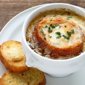 Cibulačka

Suroviny:

3 velké cibule, oloupané
50 g másla
1 lžíci hladké mouky
900 ml hovězího vývaru z kostky, vychladlého
sůl a pepř na dochucení
1 bobkový list
1/2 bagety
1 lžíci oleje na osmahnutí
70 g nastrouhaného sýra typu ementál

Postup:

Cibule pokrájejte napříč na tenká kolečka. V hrnci rozpusťte máslo a na mírném ohni smahněte cibulku 15 až 20 minut, dokud nezíská zlatohnědou barvu. Pak ji poprašte moukou, zamíchejte a ještě minutu smažte.

Přilijte vývar, osolte, opepřete, přihoďte bobkový list a zamíchejte. Uveďte směs do varu a hned stáhněte plamen. Vařte na mírném ohni půl hodiny. Potom polévku odstavte a odstraňte bobkový list.

Bagetu nakrájejte šikmo na plátky a ty opečte na pánvi na oleji dozlatova. Do hlubších misek nebo talířů nalijte horkou polévku, navrch položte vždycky dva plátky chleba a posypte je sýrem. Zapněte troubu na nejvyšší stupeň nebo na grilování a na chvilku misky vložte pod rozpálený gril. Podávejte, jakmile se sýr roztaví.