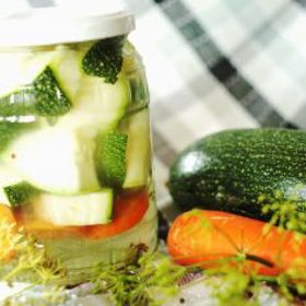 Nakládaná zelenina:

Suroviny:

1  ks květák
3  ks mrkev
3  ks cibule malá, prům. asi 3 cm
4  ks rajčata malá, ještě pevná, ne úplně dozrálá, žlutá až oranžová
3  ks paprika
4  ks kozí rohy
5  ks feferonka
1  ks kořen petržele
1  ks celer bulva
3  stroužek česnek
40  g sůl
1  l voda.

Postup:

Svaříme vodu se solí na 4% roztok (na 1 l vody 40 g soli) a necháme vychladnout. Zeleninu oloupeme a očistíme. Květák rozebereme na menší růžičky, mrkev a petržel nakrájíme na 2-3cm kousky, celer na 1cm plátky a ty na 2-3cm velké kousky. Zeleninu naskládáme do 2- nebo 5litrových lahví, skládáme těsně k sobě a zlehka je stiskneme dolů. Nahoře uděláme věneček z celerového listí a vše zajistíme dřevěnými nebo umělohmotnými pružnými proužky (pérky) tak, aby po zalití vychladlým roztokem zůstala zelenina potopená a nevyplavávala na hladinu. Naplněné sklenice se nechají stát při pokojové teplotě (nejlépe na nějakém tácu či plechu, při kvašení se stane, že voda "přešumí") tak dlouho, dokud neproběhne proces mléčného kvašení (podle teploty v místnosti tak 5 - 6 dní). Láhve se v tuto dobu nezavírají, víčko se na ně jen položí, aby se do láhví neprášilo či nespadl dovnitř nějaký hmyz. Pokud se udělá souvislý povlak, tak dolijeme solný roztok tak, až ho odstraníme (přeteče z láhve ven). Tekutina má být cca 1 cm nad zeleninou. Jakmile proběhne proces kvašení (tekutina se vyčistí - vyčeří), nasazovacími umělohmotnými víčky sklenice uzavřeme (nezavírat napevno kovovými víčky uzavírací hlavou!!!) a nechají ve sklepě (nebo spíži s konstantní teplotou - nesmí tam mrznout nebo být teplo!) asi 2 týdny dozrát. Pak je možné zeleninu jíst. Po celou dobu je třeba kontrolovat, zda je zelenina potopená a popřípadě dolévat studeným solným roztokem. Případný vytvořený šum odstraníme.