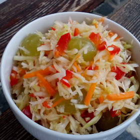 Zelný salát s hroznovým vínem:
Suroviny:
350 g bílé zelí
1 ks mrkev menší
100 g červená paprika
1 ks hroznové víno nejlépe bezsemenné, malý hrozen
sůl - špetka
hnědý cukr nebo med, dle chuti
citronová šťáva dle chuti
citronová kůra - dle chuti
1 lžička olej.
Postup:
Zelí a mrkev nakrouháme nebo pokrájíme na tenké nudličky do mísy. Přidáme špetku soli, osladíme dle chuti cukrem nebo medem a v dlaních promačkáme, aby změklo a začalo pouštět vlastní šťávu.
Do mísy přidáme drobně pokrájenou papriku, menší kuličky hroznového vína (větší přepůlíme), maličko čerstvě nastrouhané citronové kůry, olej a citronovou šťávu.
Vše promícháme a dáme na chvíli do chladna proležet.
Podáváme samostatně, ale klidně i jako součást přílohy. Ačkoliv je salát nasládlý, výborně se hodí i k masitému obědu.
Jako obměnu můžeme salát dochutit čerstvým zázvorem nebo špetkou skořice.