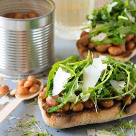 Fazolové tousty:

Ingredience:

1 stroužek česneku

400 g konzervované cizrny (lze použít i fazole)

hrstka čerstvé bazalky

šťáva z 1–2 citronů

olivový olej dle libosti

sůl a pepř dle libosti

1 vrchovatý hrnek konzervovaných nebo zavařených artyčoků

2 hrnky čerstvého baby špenátu

10 menších krajíců opečeného celozrnného chleba.

Postup: 

Rozmixujte česnek, propláchnutou cizrnu a polovinu množství bazalky, dokud nezískají drobivou konzistenci. Zbylou bazalku nakrájejte na proužky a nasekejte artyčoky. Obě přísady smíchejte s cizrnovou směsí, citronovou šťávou, bazalkou, olivovým olejem, solí a pepřem. Před podáváním vmíchejte špenát a potřete směsí opečený chléb. Salát můžete servírovat i s hranolky nebo v tortille.