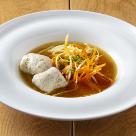 Zelenina do vývaru:
1 mrkev
1 menší celer
1 petržel / kořen/
Postup:
Mrkev, celer a petržel oškrábeme a pečlivě omyjeme pod tekoucí vodou. Škrabkou naškrábeme na tenké plátky. Tyto plátky dáme v cca 5 vrstvách na sebe a krájíme na tenké nudličky. Pokud jsou moc dlouhé, tak je překrojíme. Můžeme ještě krátce orestovat na pánvi nebo krátce povařit ve vývaru, cca 5 minut, pokud preferujeme zeleninu na skus jemnější.
Domácí nudle:
Suroviny:
140 g hrubé mouky + na podsypání
1 vejce
½ skořápky vody
Postup na nudle:
Na pracovní plochu nasypeme mouku, vyhloubíme v ní důlek, do kterého rozklepneme vejce, přidáme vodu a vidličkou vše promícháme do hustšího těsta, které ještě důkladně rukama propracujeme. Vznikne tak měkké, ale pevné a nelepivé těsto. Těsto vyválíme na tenký plát asi 1-1,5 milimetrů a dáme zaschnout pod utěrku, aby se lépe krájelo a nelepilo na nůž. Z plátu potom nakrájíme 4 cm široké proužky, ty naskládáme na sebe a odkrajujeme z nich 1 milimetr široké nudle. Nudle necháme na suchém teplém místě proschnout. Vyschlé nudle uvaříme v osolené vodě /asi dvě minuty/, přecedíme, zchladíme ve studené vodě a přidáváme do polévky.