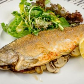 Pstruh plněný houbami

Potřebujeme: 

4 vykuchané pstruhy, 500 g čerstvých hříbků rozkrojených napůl, 2 na klínky nakrájené cibule, čerstvě mletý pepř, sůl, 3 lžíce másla, svazek petrželky a zhruba 12 listů šalvěje

Pstruzi mají velmi jemné šupiny, takže stačí, když je omyjeme. Zevnitř i zvenku ryby opepříme, osolíme a tělíčka vyplníme částí hříbků, cibule a kouskem másla. Do pekáče pak rozložíme zbytek. Provázkem ryby ovážeme, vložíme pod něj lístky šalvěje a ryby samotné dáme vedle sebe do pekáče na hříbky s cibulí. Máslem pstruhy potřeme a v troubě o teplotě 160 stupňů pečeme po dobu 20 – 30 minut