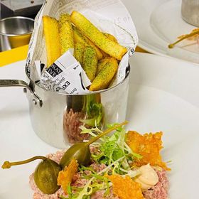 Belgický telecí tatarák
Suroviny:
400 g telecí váleček
30 g oloupané šalotky
20 g okurek Cornichon
20 g kaparů
50 g parmazánu
3x lžíce olivového oleje
1x kávová lžička soli
1x kávová lžička mletého pepře
Ochucená majonéze:
100 g kvalitní majonézy
30 g kvalitní kečup
1 x lžička citronové šťávy
1 x lžička brandy
1 x lžička worcesterské omáčky
1 x lžička tabasca
1x lžička soli
1x lžička čerstvě mletého pepře
Postup na ochucenou majonézu:
1. V misce smíchejte všechny suroviny, překryjte potravinářskou fólií a dejte na 30 minut vychladit do lednice.
Na dokončení:
1. Šalotku, okurky a kapary nakrájejte najemno.
2. Škrabkou nastrouhejte parmazán na jemné hobliny.
3. Dobře vychlazené maso nakrájejte na menší kusy a umelte na středně hrubo.
4. V misce co nejrychleji promíchejte umleté maso, šalotku, okurky, kapary, olivový olej, jednu kávovou lžičku soli a čerstvě mletého pepře.
5. Do mísy k masu přimíchejte vychlazenou ochucenou majonézu,
6. Na konec zlehka vmíchejte hoblinky parmazánu.