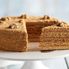 Medovník

Suroviny:

100 g másla Pilos
120 g cukru krystal Castello
50 ml plnotučného mléka Pilos
4 lžíce medu Marlene
2 vejce "M"
2 lžíce octa Pagusa
500 g polohrubé mouky Castello
1,5 lžíce jedlé sody Castello
cukrový sirup
100 g Kalifornských vlašských ořechů Alesto Fine

Krém:
500 ml plnotučného mléka Pilos
4 lžíce hladké mouky Castello
200 g másla Pilos
1 kondenzované mléko Pilos

Postup:

Těsto:
Připravíme vodní lázeň, ve které rozpustíme kousky másla, cukr, mléko a med. Směs nevaříme. Po spojení všech přísad odstavíme z vodní lázně a přimícháme vejce s octem. Takto připravenou směs nalijeme do robota. Po chvíli přisypeme polohrubou mouku smíchanou se sodou a opět promícháme. Na pomoučněném válu rukama zpracujeme těsto do tvaru válečku, který nožem rozdělíme na 4 části. Každou část zabalíme do potravinové fólie a vložíme na chvíli do lednice. Po vyjmutí vyválíme jednotlivé části těsta na pomoučněném válu do tvaru čtverce o tloušťce asi 4 mm. Každý zvlášť přendáme na pekáč vyložený pečicím papírem. Vidličkou těsto lehce propícháme. Pečeme dozlatova v předehřáté troubě na 170 °C asi 10 minut.

Krém:
Do rendlíku nalijeme mléko, nasypeme mouku a vaříme za stálého míchání metličkou do zhoustnutí. Směs přelijeme na talíř a necháme vychladnout. Do robotu vložíme máslo, mícháme a postupně po malých dávkách přidáváme připravenou kaši. Nakonec přidáme kondenzované mléko, které jsme předtím vařili ponořené ve vodě asi 3,5 hodiny.

Medovník:
Vychladlá těsta okrojíme pomocí spodní části dortové formy do kruhového tvaru a pokapeme cukrovým sirupem, který rozetřeme po celém povrchu.

Krém naneseme (stačí slabá vrstva) na první, druhou i třetí část korpusu, který na sebe navrstvíme a prsty lehce přitlačíme. Takto připravený dort potřeme zbylým krémem po celém povrchu. Na závěr posypeme rozemletými okrojky upečeného těsta, povrch uhladíme dohladka, ozdobíme ořechy a přendáme na podnos.

