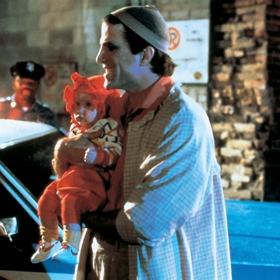 Ten však jednoho dne nečekaně naruší šokující objev na prahu jejich bytu. Před dveře totiž někdo doručil skutečné, živé, a jak se zdá, tak v tu chvíli také nevratné nemluvně.