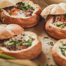 Vejce v housce
Ingredience: 4 housky, 4 vejce, 2 lžíce smetany ke šlehání 33 %, 100 g nastrouhaného extra tvrdého sýru (Gran Moravia), 100 g kvalitní slaniny, máslo, hrst čerstvé pažitky, hrst čerstvé hladkolisté petržele
sůl, čerstvě mletý pepř