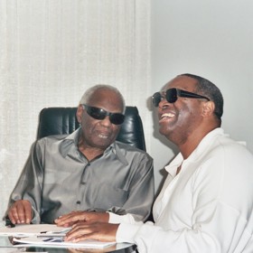 Tmavé brýle a úsměv na tváři. Dva hlavní poznávací znaky Raye Charlese.
