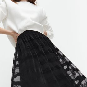 Zdánlivě formální sukni se nebojte sladit s mikinou a teniskami