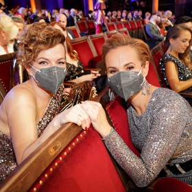 Flitrové šaty oblékly na loňských Slavících zpěvačky Monika Absolonová a Marta Jandová. Každá z dam je však doplnila jiným účesem. Zatímco Monika své kratší vlasy elegantně načesala dozadu, Marta vlasy nejprve natočila a následně je sepnula do nedbalého drdolu na pravé straně, který společně s odhaleným ramenem vypadal opravdu perfektně.