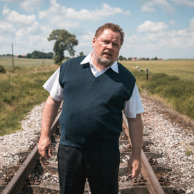 ...strojvedoucí Miloš (Václav Kopta) musí zastavit uprostřed polí a vystoupit. Vlak se sice záhy pohne, ale bez Miloše. Ten zůstává osamocen na kolejích.