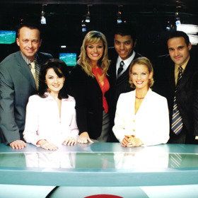 Televizní noviny v obsazení Karel Voříšek, Jana Adámková, Lucie Borhyová, Rey Koranteng, Pavla Charvátová a Pavel Zuna.