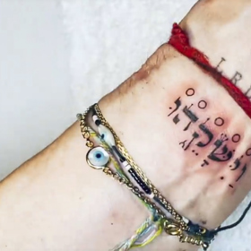 Na zápěstí má počáteční písmena jmen svých šesti dětí, hebrejské slovo, které v překladu zní „políbená", a na druhé ruce černé X.