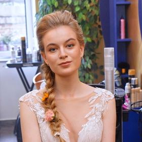 Dlouhé blonďaté vlasy Michaely Pecháčkové kadeřnice zapletla do působivého copu, který ozdobila živými květinami.