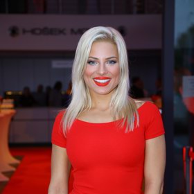 Eva Perkausová v jednoduchých elegantních červených pouzdrových šatech.