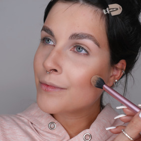 Pomocí bronzeru vykonturujte lícní kosti. Nanášejte ho směrem vzhůru, abyste opticky pozvedla obličejové rysy.