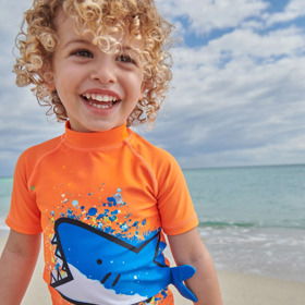 Oranžová dvoudílná souprava tílka a šortek se žralokem. NEXT, 685 Kč.  