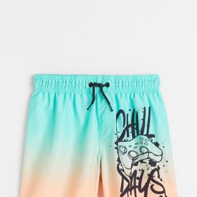 Tyrkysové plavecké šortky s potiskem. H&M, 349 Kč. 