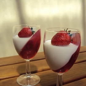 Panna cotta s jahodami může mít spoustu podob. Když je naskládáte do nakloněné sklenice a až potom zalejete želé a panna cottou, vznikne tento neotřele vypadající dezert.