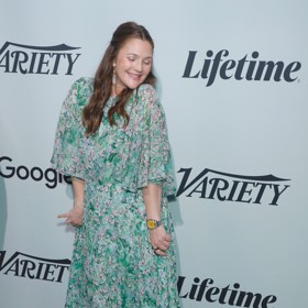 Letní outfit Drew Barrymore v podobě květovaných maxi šatů a červených lodiček. Šaty lze navíc doplnit koženou či džínovou bundou, a jednoduše tak vytvořit outfit vhodný na podzim.