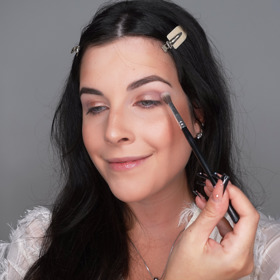 Dále si z paletky beru světlý matný stín a pomocí většího kulatého štětce ho začnu nanášet do ohybu víčka. Používám k tomu především krouživé pohyby a dávám si pozor na to, abych se stínem nevyjela až příliš k obočí jelikož by to ve finálním líčení nevypadalo dobře.  