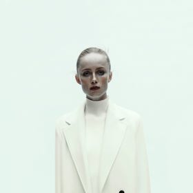 Monochromatický, tedy jednobarevný outfit vám opticky přidá centimetry, protože linie postavy není nikde rozdělena. Další super tip. Bílý kabát Zara, 1799 Kč