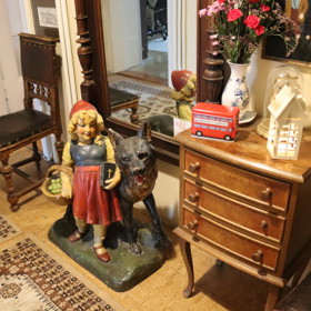 Pod zrcadlem v předsíni nechybí velká figurína vlka s červenou Karkulkou.