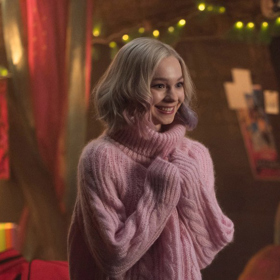 Roztomilá Enid v růžovém svetru, který jí ladí s pastelovými melíry.