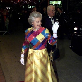 Královna Alžbeta II. a její vtipné barevné šaty, které oblékla při královském varietním představení v listopadu 1999.