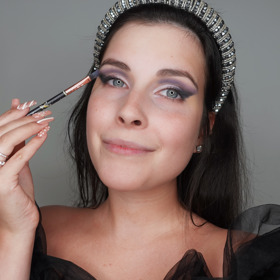 Po nanesení korektoru na oční víčka jsem použila tmavě modrý odstín do ohybu víčka a následně ho rozpracovala fialovým stínem do ztracena. Do vnějšího koutku jsem nanesla nejtmavší černý stín z paletky pro zvýraznění tvaru líčení. Na pohyblivé víčko jsem použila metalický světlý stín a nanesla ho prstem, aby pigmenty lépe vynikly.