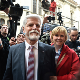 Generál Petr Pavel přišel do volebního štábu za doprovodu své manželky Evy. Ta oblékla zářivě červený kabát. 